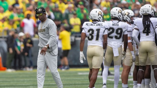 Colorado coach Deion Sanders leaves his team's huddle during timeout against Oregon.